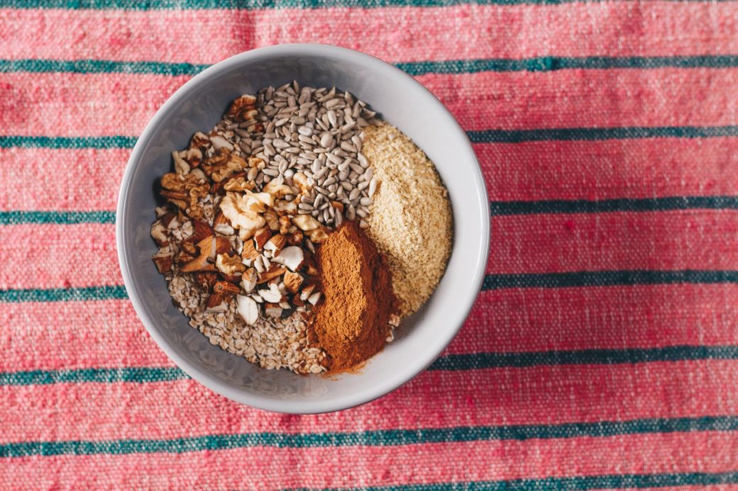 A nutritious blend of oats, nuts, and seeds in a bowl on a vibrant tablecloth.