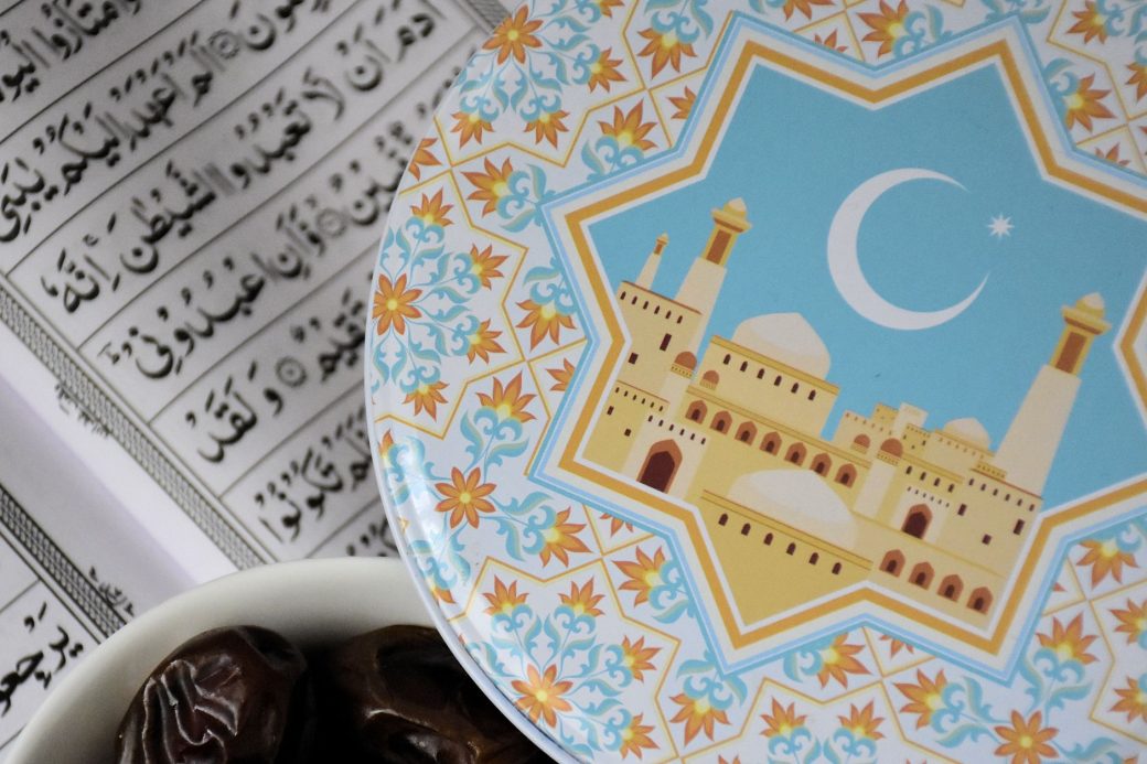 Decorative Ramadan plate with mosque illustration, dates, and Quran text, symbolizing Islamic fasting.