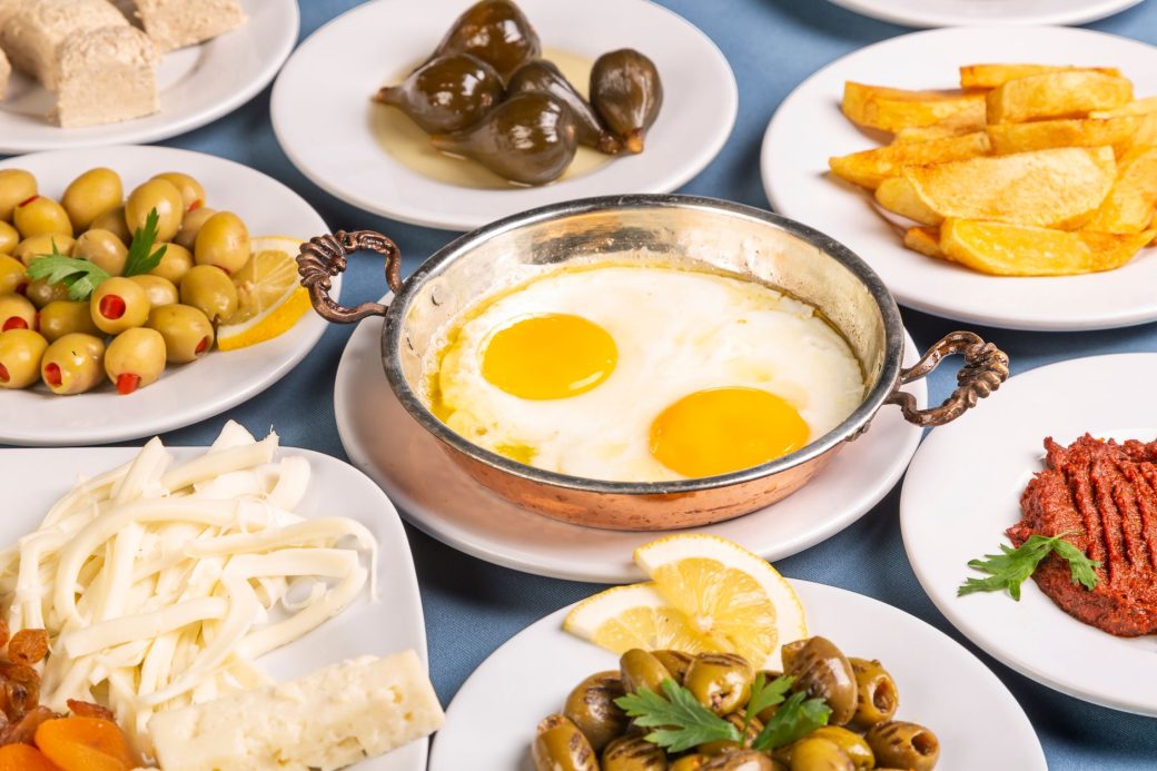 Enjoy a vibrant Turkish breakfast with eggs, olives, and cheese in Bursa, Türkiye.