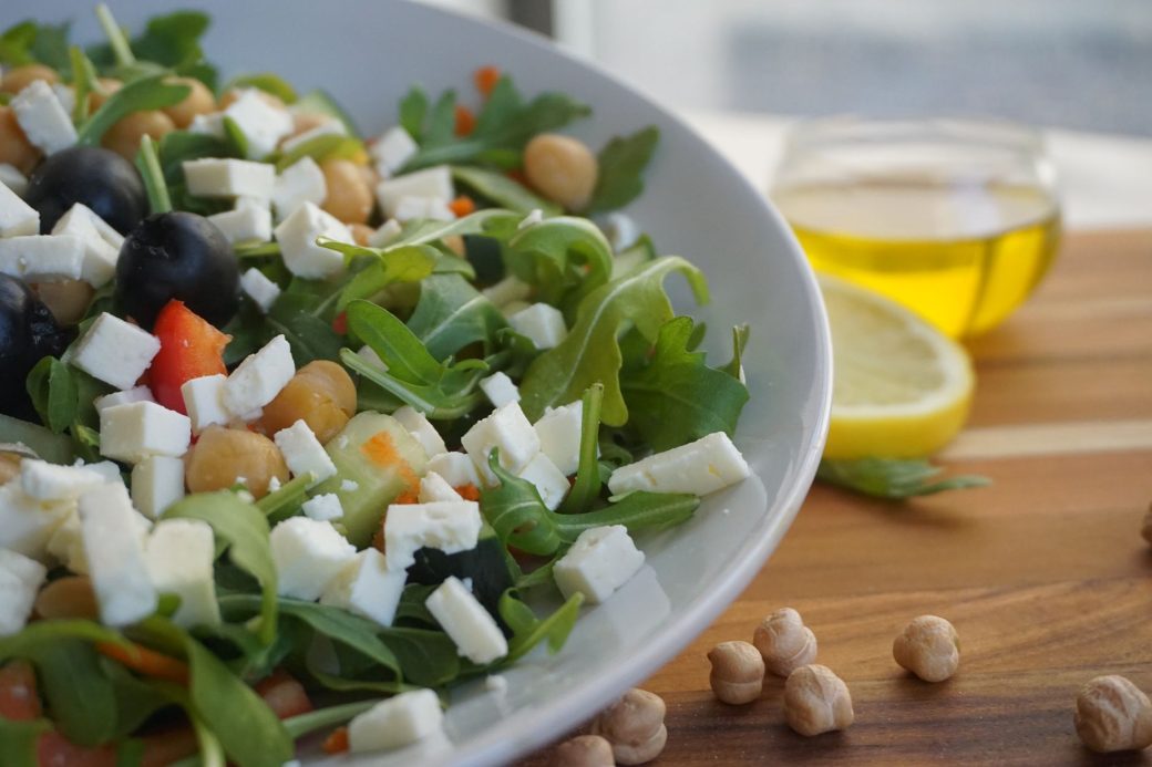 A colorful Mediterranean salad featuring feta, olives, chickpeas, and fresh greens.